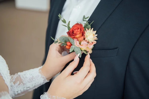 Dışarıda gelinin elleri. Gelin damat düğün ceketi üzerinde boutonniere düzeltir — Stok fotoğraf