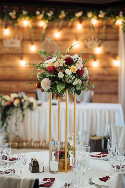 Una composición de flores y verde está en una mesa festiva en la sala de banquetes de boda . — Foto de Stock