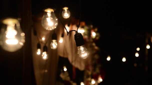 Lampy się zamykają. Ślubne girlandy, które świecą na łuku. Nieszpory Ceremonia ślubna — Wideo stockowe