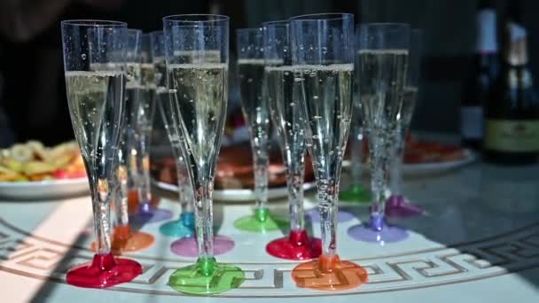 Tiro de copos de champanhe alinhados em fileiras em uma mesa que espera pelos hóspedes de recepção de casamento — Vídeo de Stock