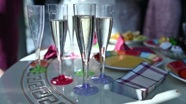 Shot van glazen champagne opgesteld in rijen op een tafel te wachten op de bruiloft receptie gasten — Stockvideo
