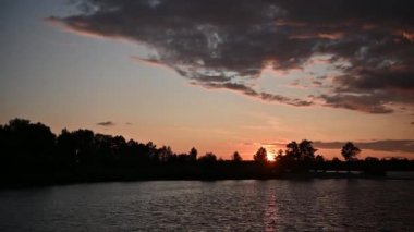 güzel bulutlar ile nehir üzerinde güzel turuncu gün batımı