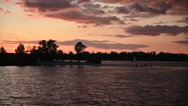 Prachtige oranje zonsondergang op de rivier met prachtige wolken — Stockvideo