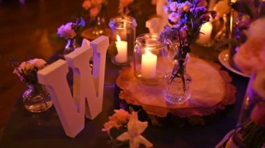 Mumlar ve kırmızı güllerle romantik bir akşam yemeği için pahalı bir masa.