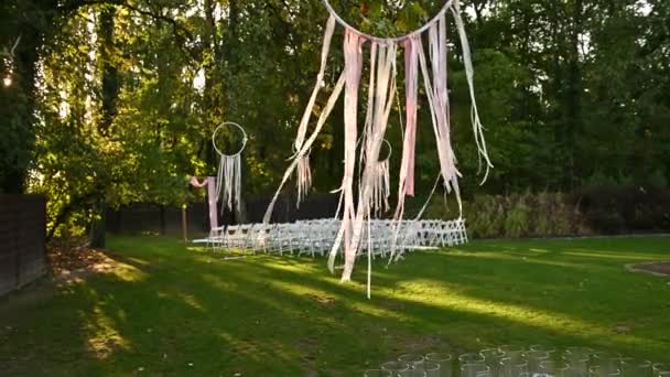 Decoração cerimônia de casamento no vento. Vento sopra fitas coloridas na luz solar da primavera — Vídeo de Stock