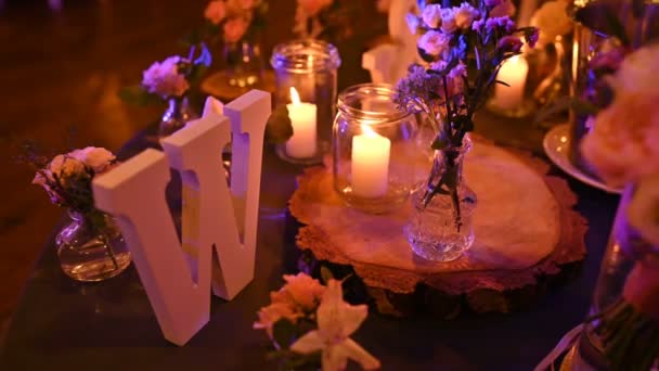 Όμορφο ακριβό τραπέζι που σερβίρει για ένα ρομαντικό δείπνο με κεριά και κόκκινα τριαντάφυλλα — Αρχείο Βίντεο