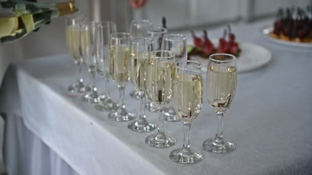 Chupito de copas de champán alineadas en filas en una mesa esperando a los invitados de la recepción de la boda — Vídeos de Stock