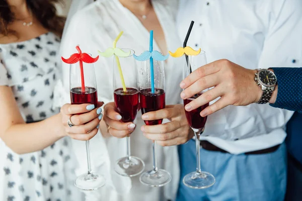 group of people touch champagne glasses and cocktails