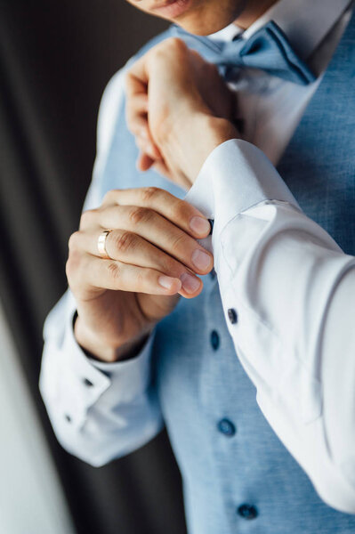 Man buttons cuff link on cuffs sleeves luxury white shirt.