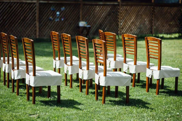 Σειρές από καρέκλες με λευκές κάπες για τους καλεσμένους σε μια γαμήλια τελετή εκδήλωση έξω — Φωτογραφία Αρχείου