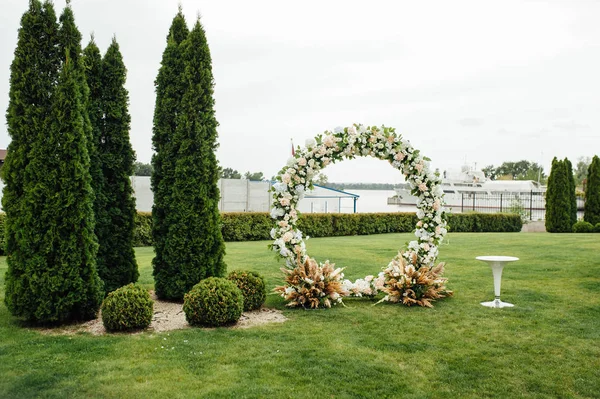 Arco para a cerimônia de casamento, decorado com pano e flores — Fotografia de Stock