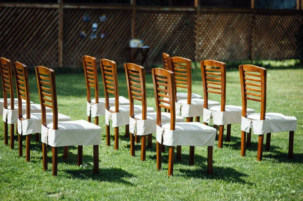 Σειρές από καρέκλες με λευκές κάπες για τους καλεσμένους σε μια γαμήλια τελετή εκδήλωση έξω — Φωτογραφία Αρχείου