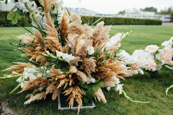 Boog voor de huwelijksceremonie, versierd met stof en bloemen — Stockfoto