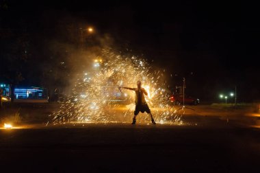 Parlak dönen ateş kıvılcımlar saçar ve gecenin içinde ateş gösterisi