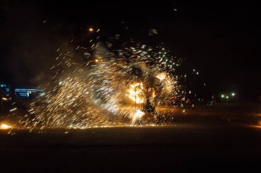 Parlak dönen ateş kıvılcımlar saçar ve gecenin içinde ateş gösterisi