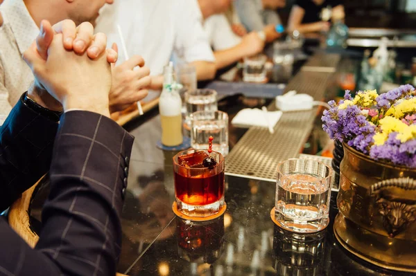 Group of friends having drinks whiskey at the night club after work .