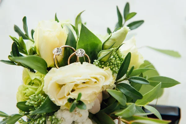 Gouden trouwringen met bloemen rond-close-up. zonnige dag — Stockfoto