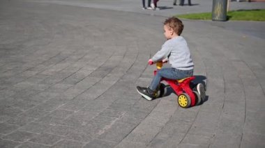Çocuk iyi bir ruh hali olan yaz güneşli havalarda parkta bir runbike sürmek