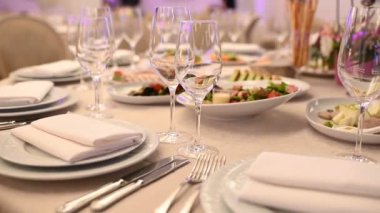 Çatal bıçakla süslenmiş ziyafet masası. Şölen salonunda düğün dekorasyonu..