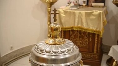 Golden cross on a font lid in a church
