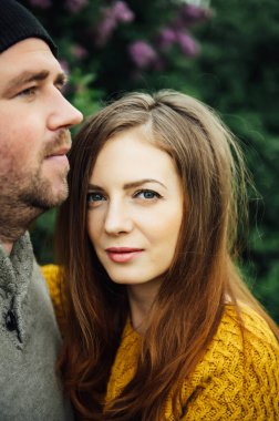 Beautiful couple in love is hugging near a lilac bush. lifestyle photo