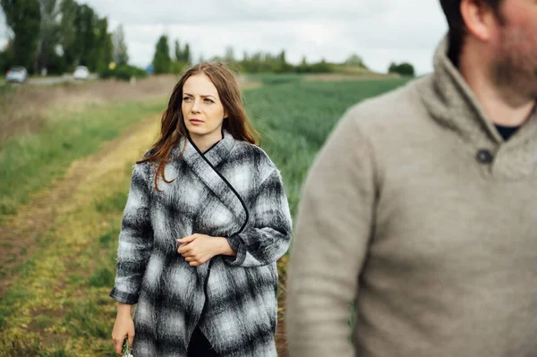 Os amantes jovens caminham perto do campo de trigo cedo. Abraço e divirta-se — Fotografia de Stock