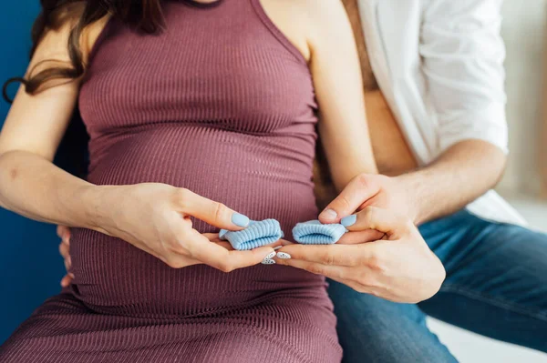 Zugeschnittenes Bild eines glücklichen Paares zu Hause. Mann umarmt seine schwangere Frau. — Stockfoto