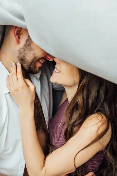 Loving couple hugs at the window. Uncertain people in the photo — Stock Photo, Image