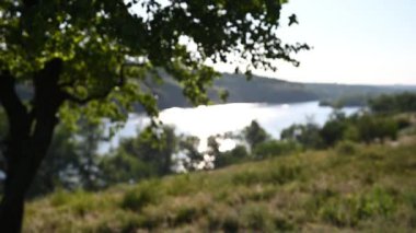 Gün batımında manzara çok güzel. Hafif bir rüzgar çimenleri ve ağaçları sallıyor.