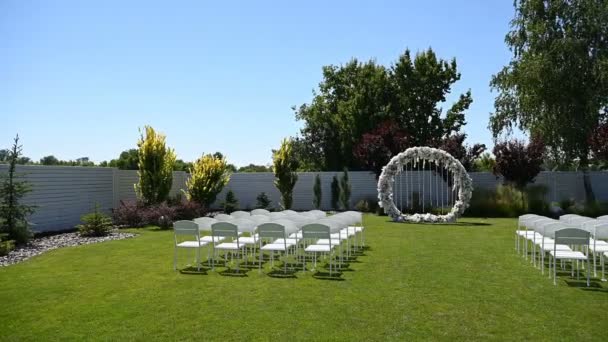 Variété de chaises pliantes blanches dans la zone de réception du mariage lors de la cérémonie de mariage. — Video