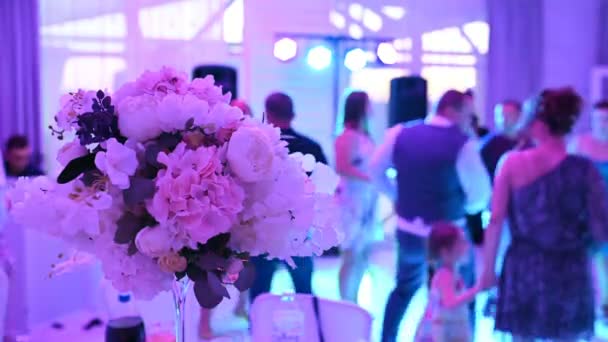 Les gens dansent sur le fond de fleurs. Fête de mariageLes gens dansent à un mariage — Video