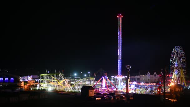 Evening view of the amusement park. Ferris wheel and other forms of entertainment — Stock Video