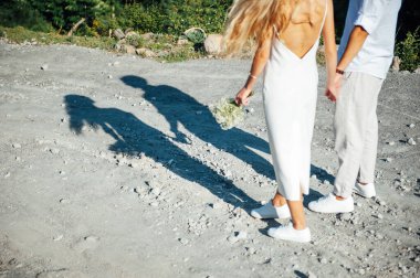 Yeşil bir parkta birlikte yürüyen mutlu genç çift.