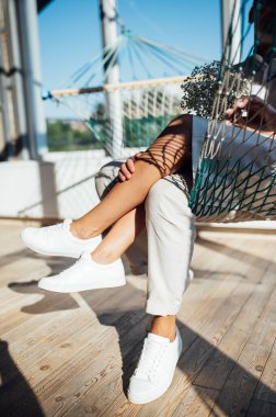 Birbirine aşık çiftler, güneşin altında hamakta eğlenirler.