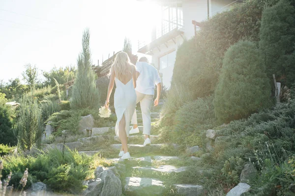 Glada unga par går tillsammans i en grön park — Stockfoto