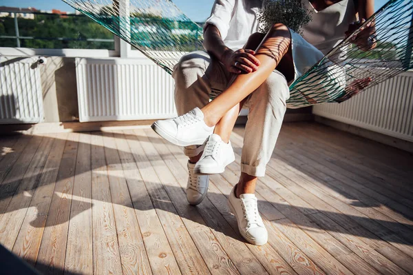 Couple amoureux s'amuse sur un hamac en maille, au soleil — Photo