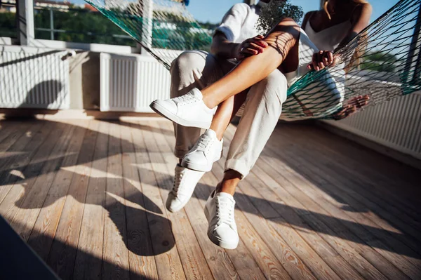 Casal apaixonado se diverte em uma rede de malha, ao sol — Fotografia de Stock