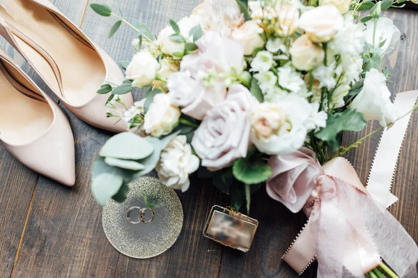 Luxus esküvői csokor a menyasszony és a vőlegény gyűrűi mellett. A menyasszony cipője magassarkúban — Stock Fotó