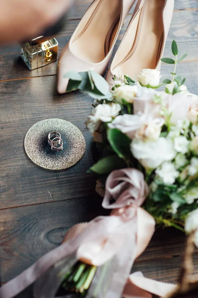 Luxe bruiloft boeket naast de ringen van de bruid en bruidegom. De bruiden schoenen met hakken — Stockfoto