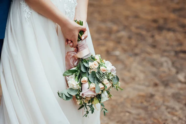 Beau bouquet de mariage dans les mains de la mariée dans la forêt — Photo