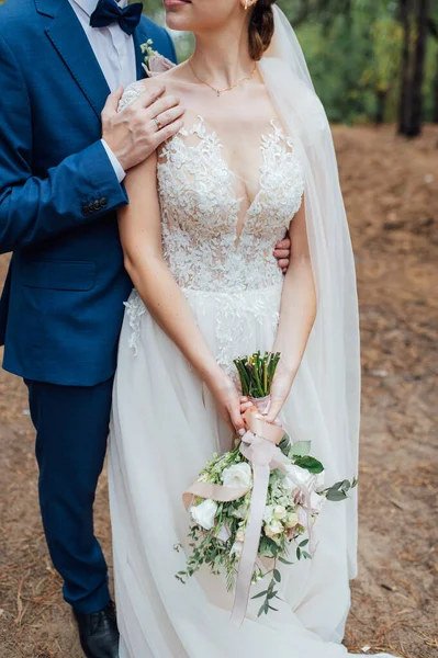 Marido y mujer legal abrazándose con un ramo en sus manos después de la ceremonia — Foto de Stock