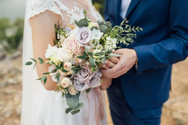행복 한 신부와 신랑이 손에 꽃다발을 들고 껴안는 모습 — 스톡 사진