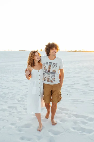 Casal de férias andando na praia juntos no amor segurando ao redor uns dos outros. — Fotografia de Stock