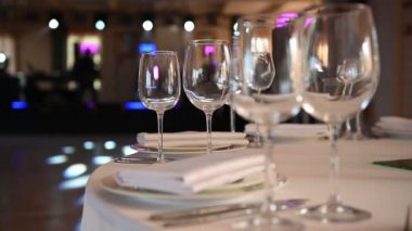 Lüks restoran. Lüks içecekler, beyaz masalar, misafirler için servis tabakları ve bardaklar.