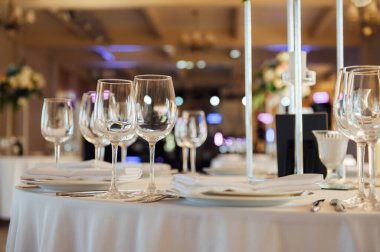 Lüks restoran. Lüks içecekler, beyaz masalar, misafirler için servis tabakları ve bardaklar.