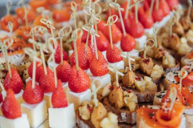 Sandviç, kanepe ve kekler festival masasında. Çok çeşitli atıştırmalıklar.