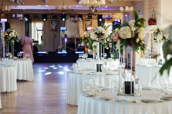 Een prachtige vaas bloemen op een tafel in een luxe restaurant. Bruiloft decoraties — Stockfoto