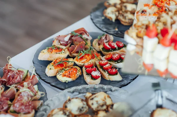 Sandwiches, canapes and cakes on the festive table. A wide variety of snacks — Stock Photo, Image