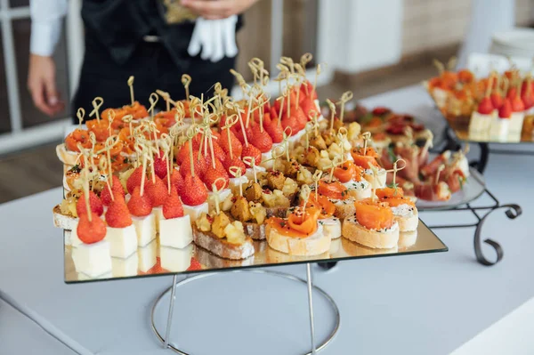 Broodjes, hapjes en gebak op de feesttafel. Een grote verscheidenheid aan snacks — Stockfoto