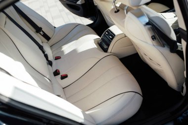 Premium bir arabanın arka koltuğu. Bej deri ve kontrol sistemi